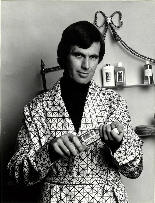 A man holding a bottle of perfume