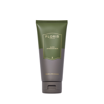 A green and gray tube of Floris London Elite Aftershave Balm 100ml stands upright, gold and white text highlighting its formula against a white background.