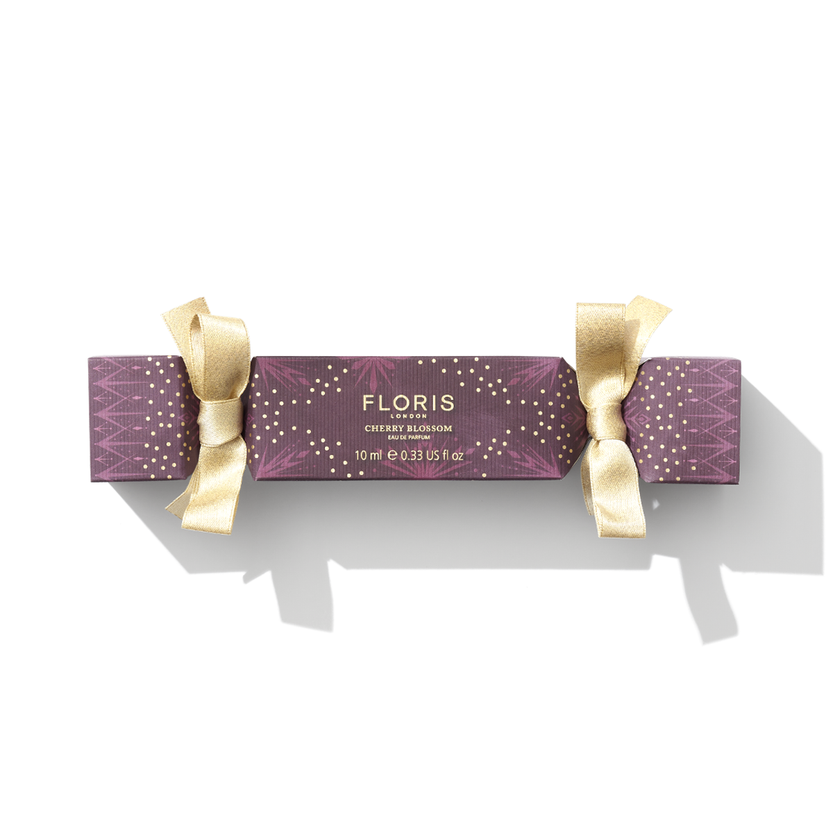 A purple and gold holiday cracker labeled "Cherry Blossom Holiday Cracker" from Floris London EU evokes the charm of a British tradition during the festive holiday season.