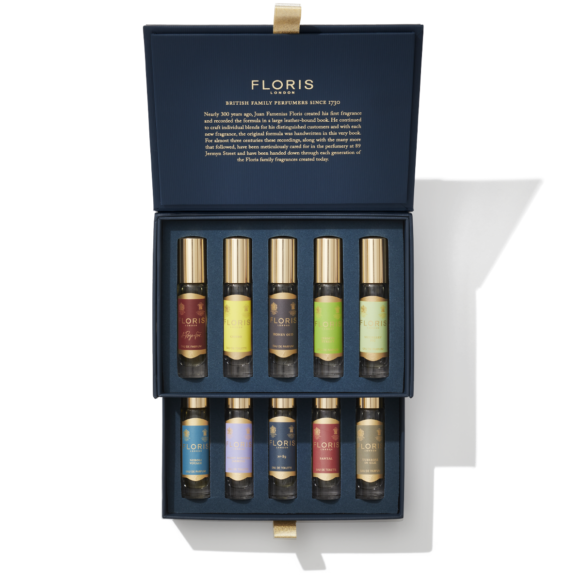The Perfumer's Collection by Floris London EU is presented in a blue box containing ten small vials of assorted perfumes, each with colorful labels. The box lid features text detailing the brand's history and description, making it an ideal gift for the discerning connoisseur.