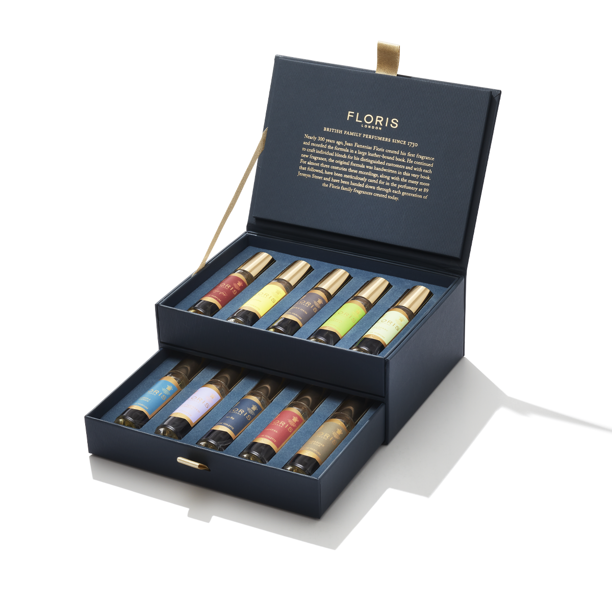 Introducing "The Perfumer's Collection" by Floris London EU, an essential for any perfume connoisseur. This elegant blue box contains nine perfume bottles arranged in two rows, each adorned with gold-colored caps. The sophisticated lid features the brand name "Floris London EU" and a descriptive inscription in gold lettering, making it a perfect gift.