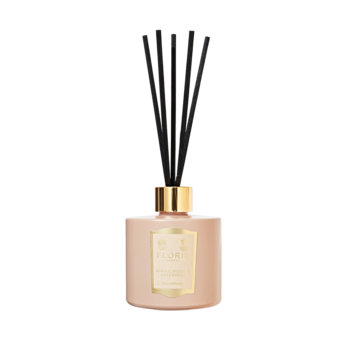 A beige Floris London reed diffuser with black reeds and gold details, labeled "Sandalwood & Patchouli" for a woody amber scent experience.
