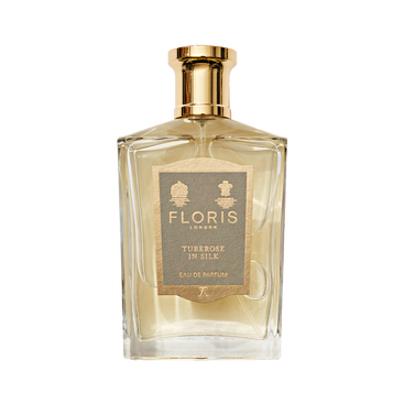 A clear glass bottle of Floris London Tuberose in Silk Eau de Parfum, a luxurious tuberose scent with a gold cap and beige front label.