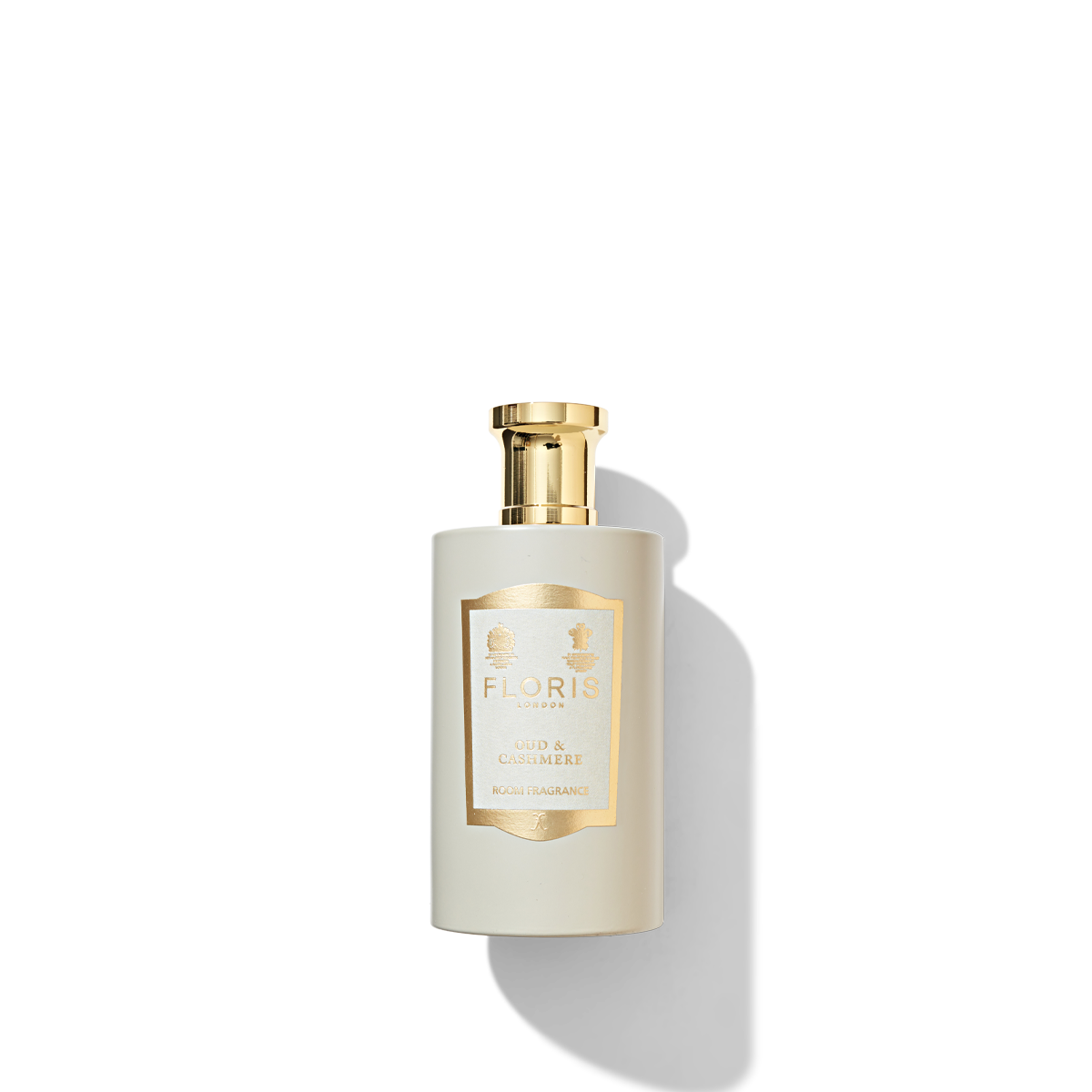 Oud & Cashmere Room Fragrance in a matte beige coloured glass with a cream and gold label and a shiny gold cap. 