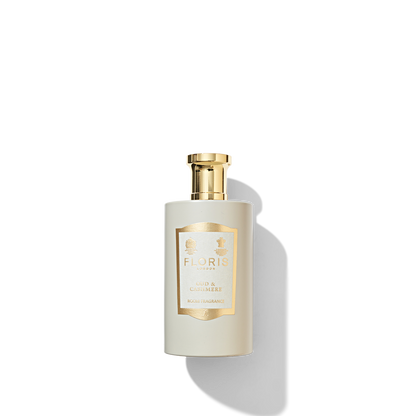 Oud & Cashmere Room Fragrance in a matte beige coloured glass with a cream and gold label and a shiny gold cap. 