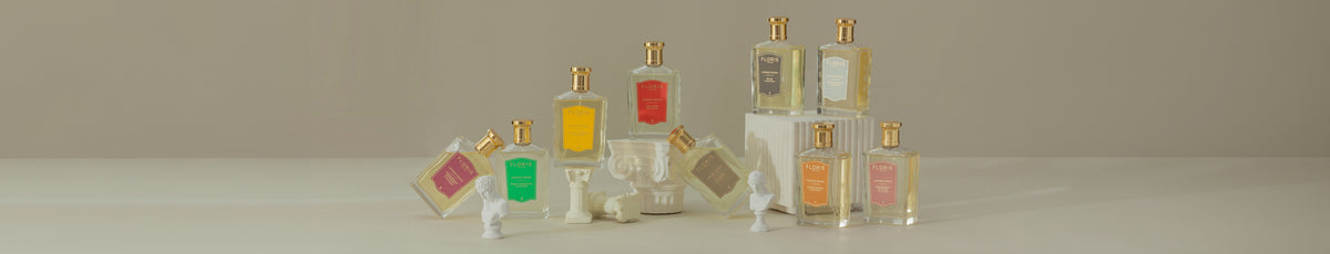 Several perfume bottles with different colored labels are displayed alongside small statues and chess pieces.