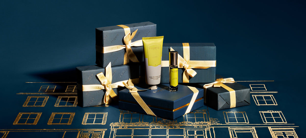 Black gift boxes with gold ribbons arranged in a diagonal pattern on a dark surface.