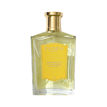 A clear glass bottle of Floris London Bergamotto di Positano Eau de Parfum, featuring a gold cap, yellow label, and pale yellow fragrance inside.