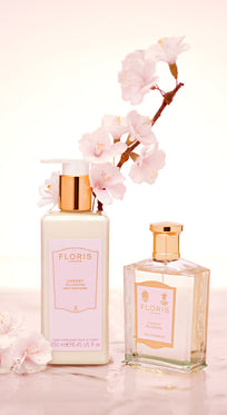 Two Floris London UK Cherry Blossom - Enriched Body Moisturisers on a pink marble surface, with cherry blossoms.