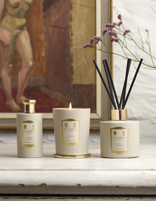 The Floris London Oud & Cashmere Home Collection on a side table, with a painting in the background.  