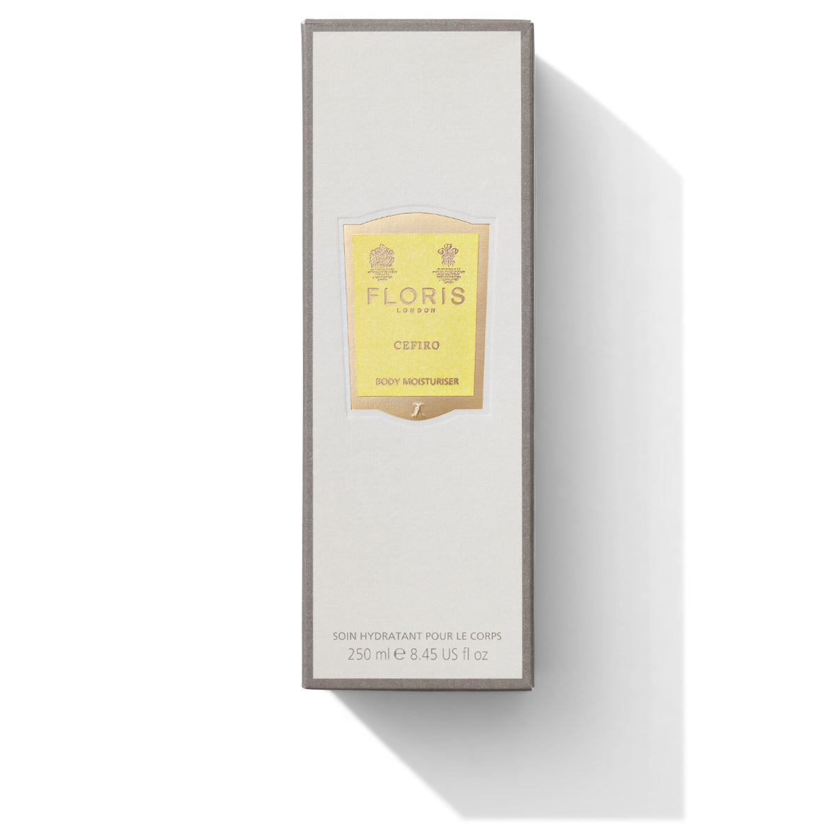 A rectangular box of Floris London Cefiro - Enriched Body Moisturiser, 250 ml. The luxuriously scented moisturiser comes in a white box with a yellow label, shadows cast to the right, and is enriched with anti-ageing vitamin E.