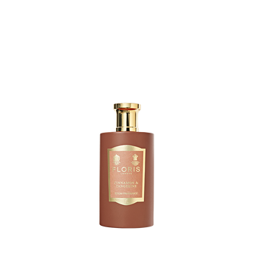 A brown bottle with a gold cap and label reads "Floris London Cinnamon & Tangerine - Room Fragrance," showcasing a rich spice scent. White background.