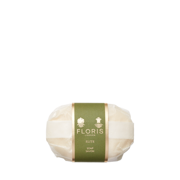 A wrapped Floris London EU Elite Soap bar with a green and gold label, featuring woody notes, is shown against a plain white background.