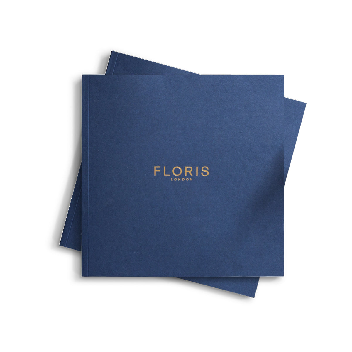 Two deep blue booklets titled "2024|25 Catalogue" by Floris London EU, featuring gold-printed covers, ideal as coffee table books that elegantly display a collection of luxurious fragrances.