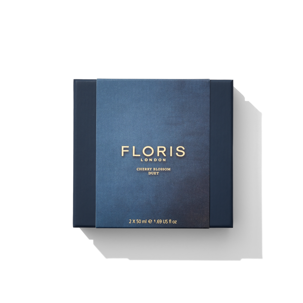A square box featuring a dark blue cover with "Floris London EU Cherry Blossom Duet" in gold text, this gift set includes two 50 ml bottles, totaling 1.69 fl oz., capturing the delicate intensity of Cherry Blossom.