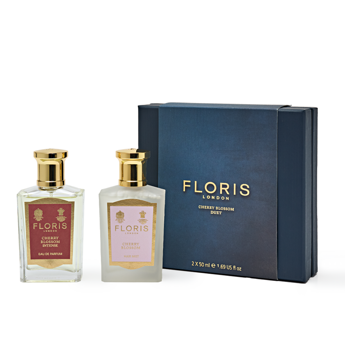 A gift set featuring the "Cherry Blossom Duet" by Floris London EU includes two elegantly presented bottles—one labeled "Floris London Cherry Blossom Intense" and the other simply "Cherry Blossom"—both standing proudly next to a navy blue box with gold lettering, exuding an aura of intensity and elegance.