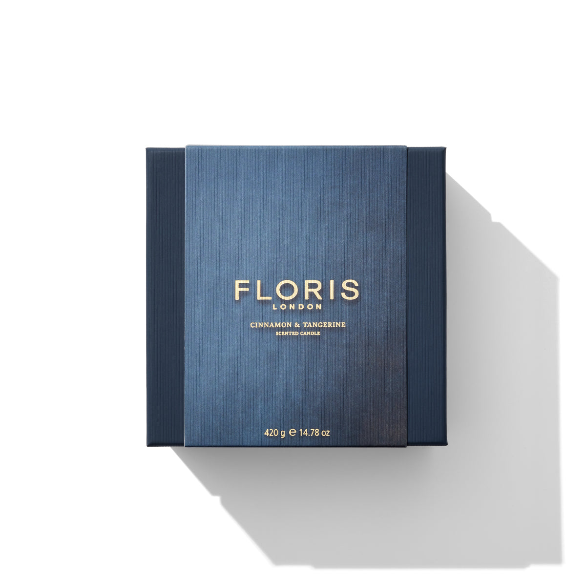 A square box containing the Cinnamon & Tangerine Deluxe Three Wick Candle from Floris London EU. The blue box with gold text houses 420 g (14.78 oz) of aromatic elegance.