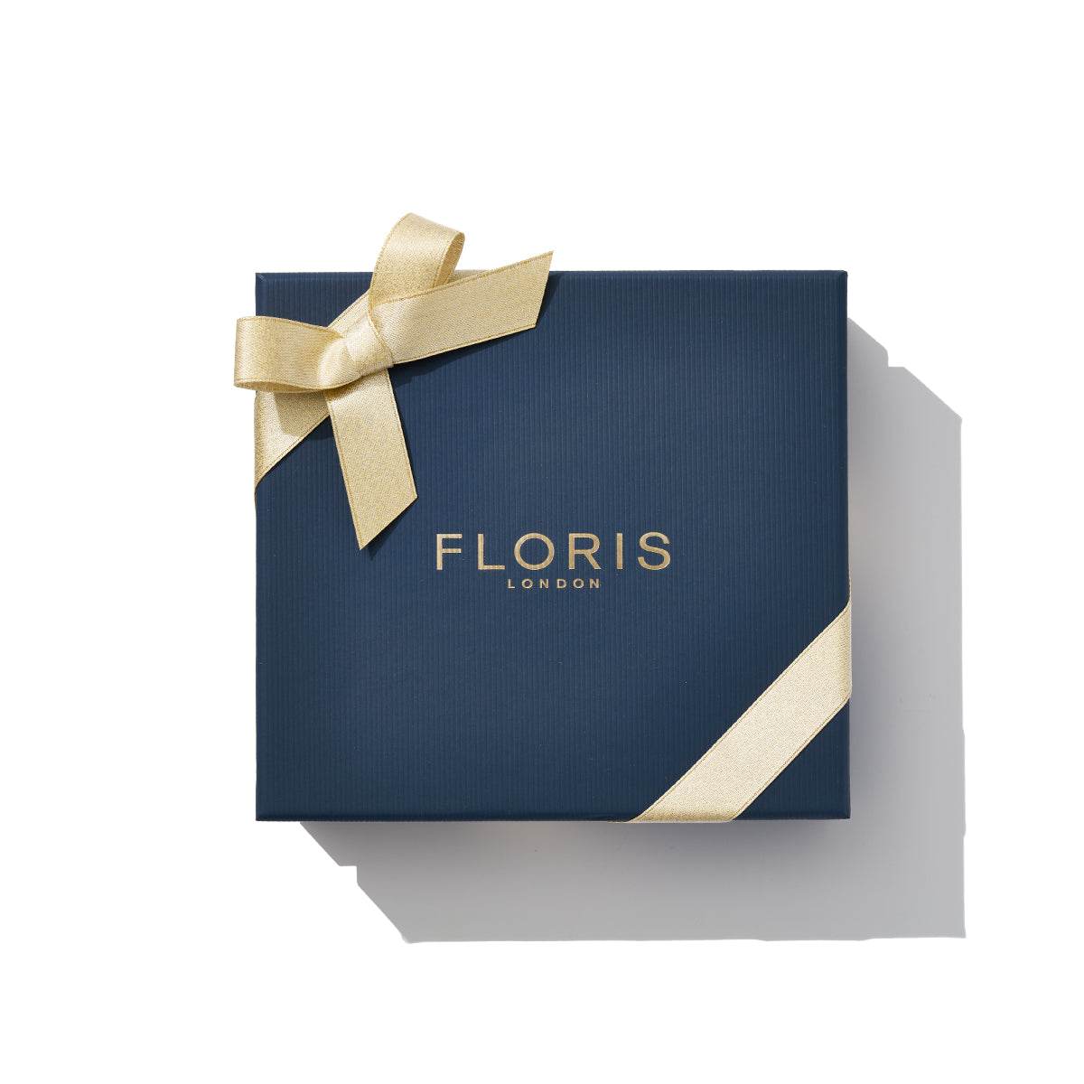A navy box with "Floris London EU" in gold text and a gold ribbon, perfect for the Perfumer's Trilogy: For Him, a set of British men's fragrances.