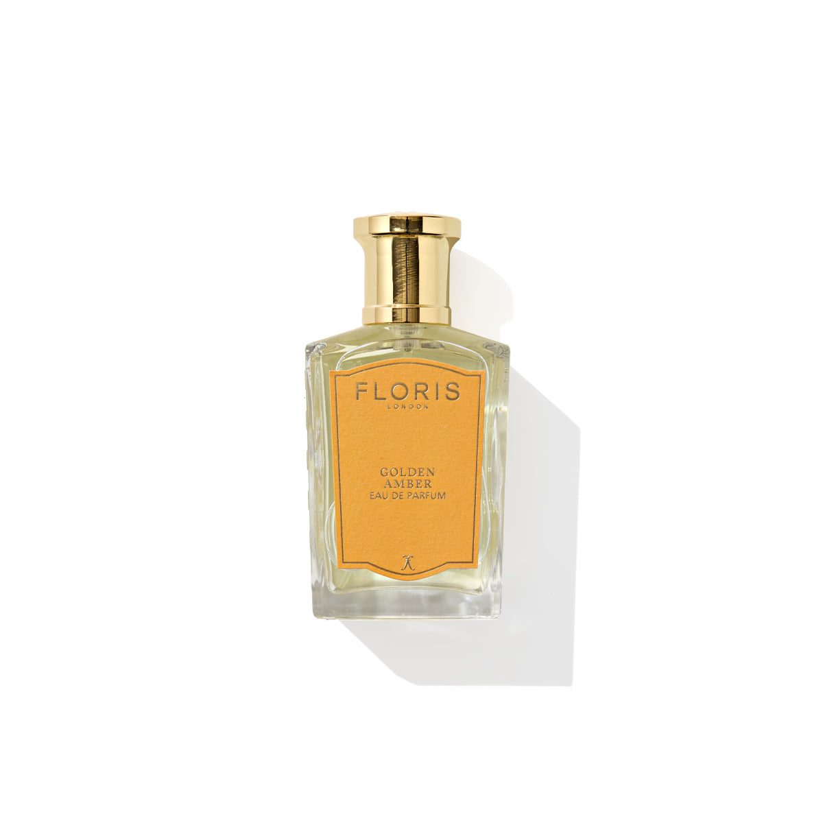 A rectangular glass bottle with a gold cap contains Golden Amber - Eau de Parfum by Floris London. The label on the bottle is warm yellow, featuring the product name and brand in black text, suggesting its floral heart and delicate aquatic notes.