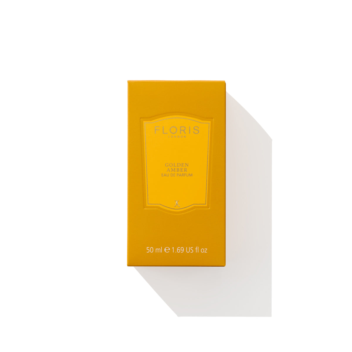 A yellow, rectangular box of Floris London Golden Amber - Eau de Parfum, 50 ml, featuring a floral heart and delicate aquatic notes, shown against a white backdrop with its shadow visible.