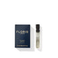 A 2 ml sample vial of Floris London Golden Amber - Eau de Parfum is positioned next to its elegant navy blue box, both emanating a harmonious blend of aquatic notes and a floral heart, all set against a pristine white backdrop.