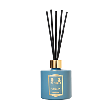 A Hyacinth & Bluebell Reed Diffuser by Floris London, with a blue bottle, gold label and cap, and black reeds, evokes a fresh green floral scent.