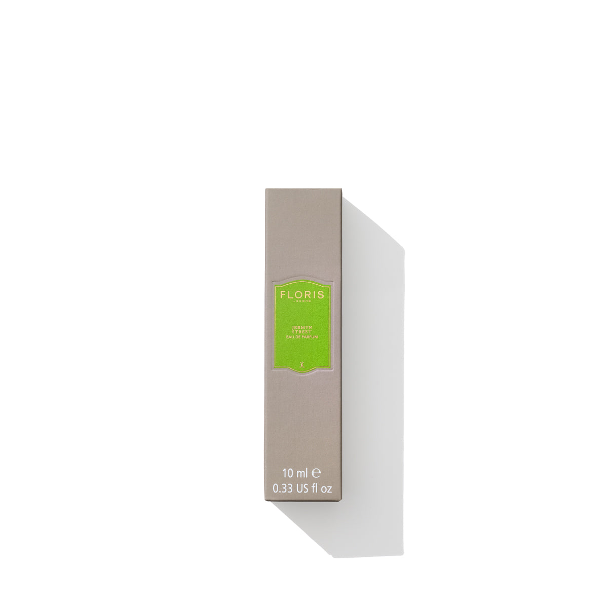 A small beige rectangular box with a green label, containing Floris London brand Jermyn Street Eau de Parfum, 10 ml (0.33 US fl oz). This vegan perfume also features subtle notes of gin and vetiver fragrance. The box casts a shadow.