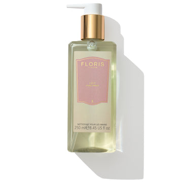 A bottle of Floris London EU's Lily - Luxury Hand Wash with a pump dispenser, containing 8.45 fl oz (250 ml) of liquid. The label is pink with gold accents, and the hand wash boasts an uplifting floral fragrance that leaves your hands feeling refreshed and gently scented.
