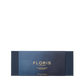 A rectangular blue Floris London EU box with gold text holds three 70g Miniature Candle Collection candles, elegantly displayed on a white background.