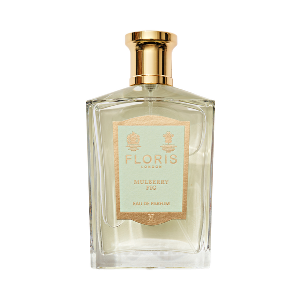 Clear glass perfume bottle with gold cap, labeled "Mulberry Fig - Eau de Parfum" by Floris London, exuding a floral amber fragrance.
