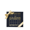 A square, dark blue Perfumer’s Trilogy: For Her gift box decorated with a gold line drawing of a storefront and tied with a gold ribbon.