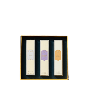 A gold-edged box holds three 10ml bottles of Floris London EU’s Perfumer's Trilogy: For Her, each in a white package with colorful labels.