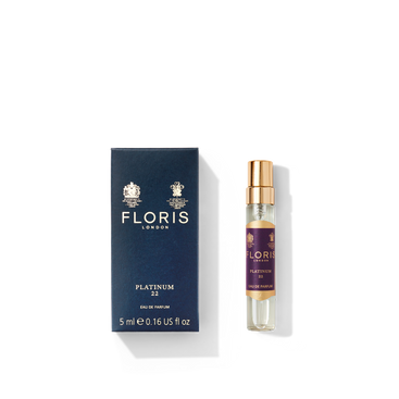 The perfume packaging includes a navy blue box from Floris London, marked with "Platinum 22 - Eau de Parfum 5ml," as well as a transparent spray bottle featuring a gold cap. This luxurious fragrance combines aromatic notes with vetiver undertones, encapsulated in style and elegance.