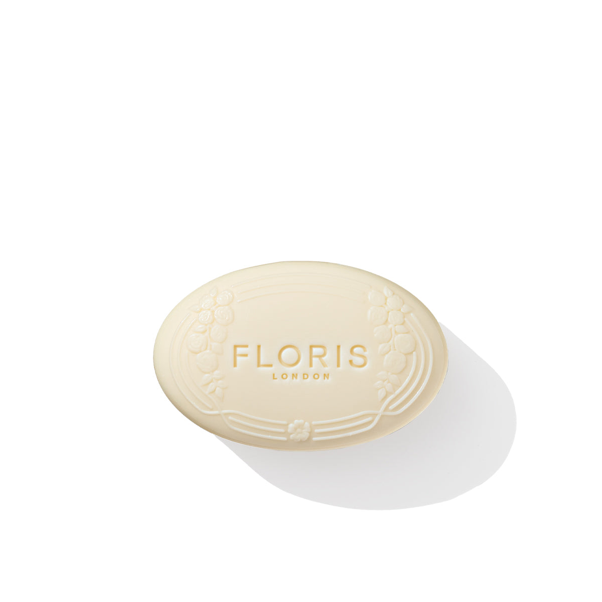 An oval-shaped, beige soap bar embossed with "Floris London EU" and a decorative border, labeled as Rose Geranium Soap, casts a shadow on a white background.