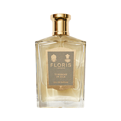 A clear glass bottle of Floris London Tuberose in Silk Eau de Parfum, a luxurious tuberose scent with a gold cap and beige front label.