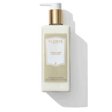 A 250 ml (8.45 fl oz) cream bottle of Floris London EU White Rose Hand Lotion, featuring a gold-capped pump dispenser, enriched with soothing sweet almond oil and vitamin E for added nourishment.
