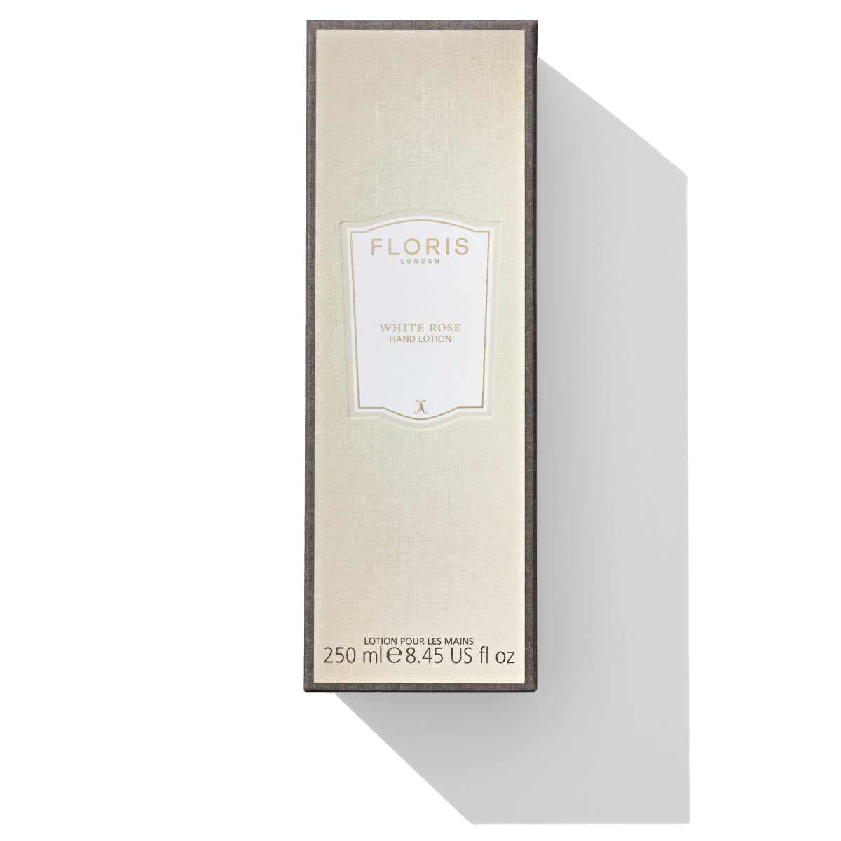 A beige rectangular Floris London EU White Rose Hand Lotion box with a shadow cast to the right. Enhanced with vitamin E and soothing sweet almond oil, the box contains 250ml (8.45 US fl oz) of product.