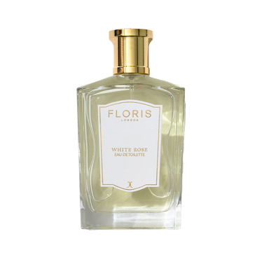 A clear glass bottle of Floris London White Rose - Eau de Toilette, a vegan fragrance with a gold cap and white label, photographed on a light background.