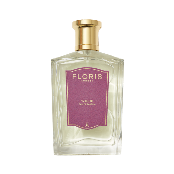 Clear glass bottle of Floris London's Wilde Eau de Parfum, inspired by Oscar Wilde, with a gold cap and purple label celebrating individuality.