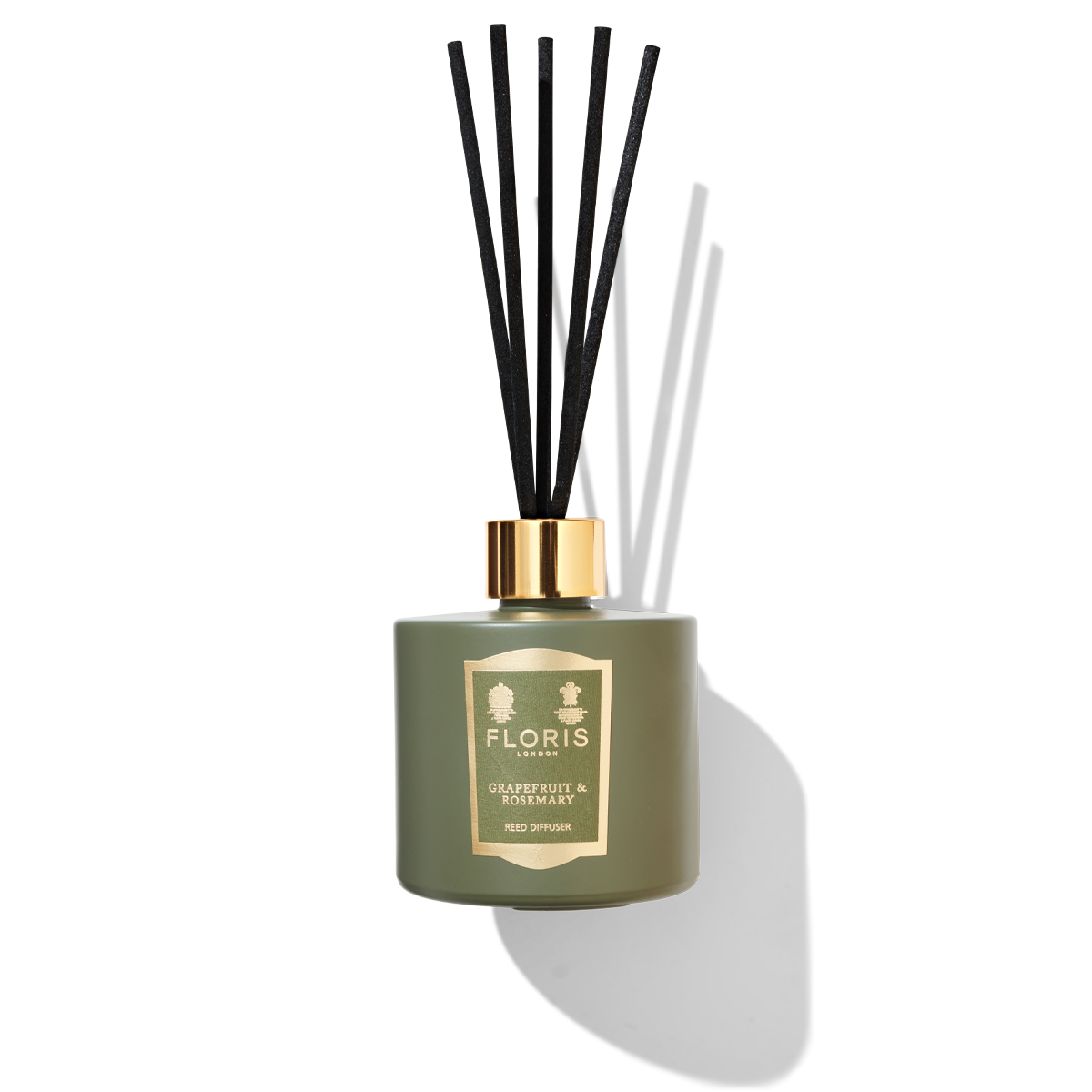 Jungle green reed diffuser with 5 black reeds. a green and gold label with Floris london grapefruit and rosemary printed.