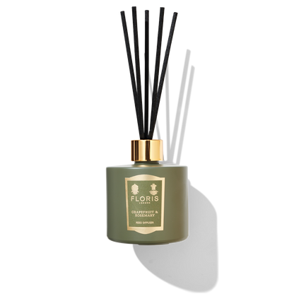 Jungle green reed diffuser with 5 black reeds. a green and gold label with Floris london grapefruit and rosemary printed.