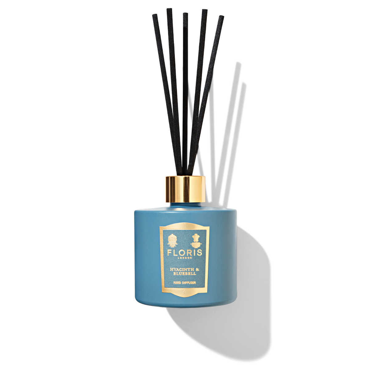 Sky blue reed diffuser bottle with 5 black reeds in a blue and gold label reading ' hyacinth and bluebell reed diffuser'.