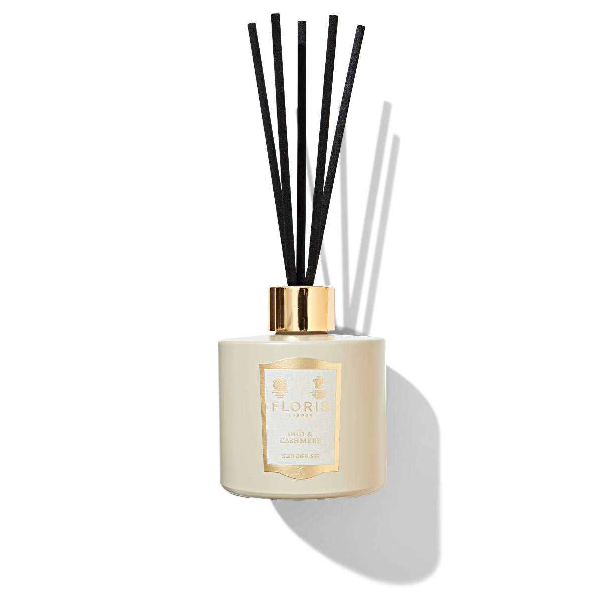 Oud & Cashmere Reed Diffuser in a beige coloured jar with a cream and gold label, shiny gold cap and 5 black reeds. 