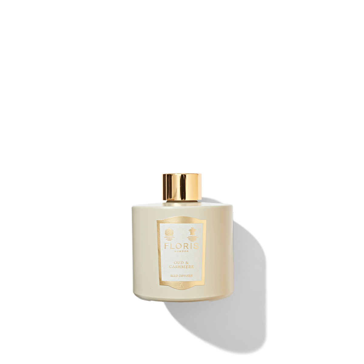 Oud & Cashmere Reed Diffuser in a beige coloured jar with a cream and gold label, and a shiny gold cap.