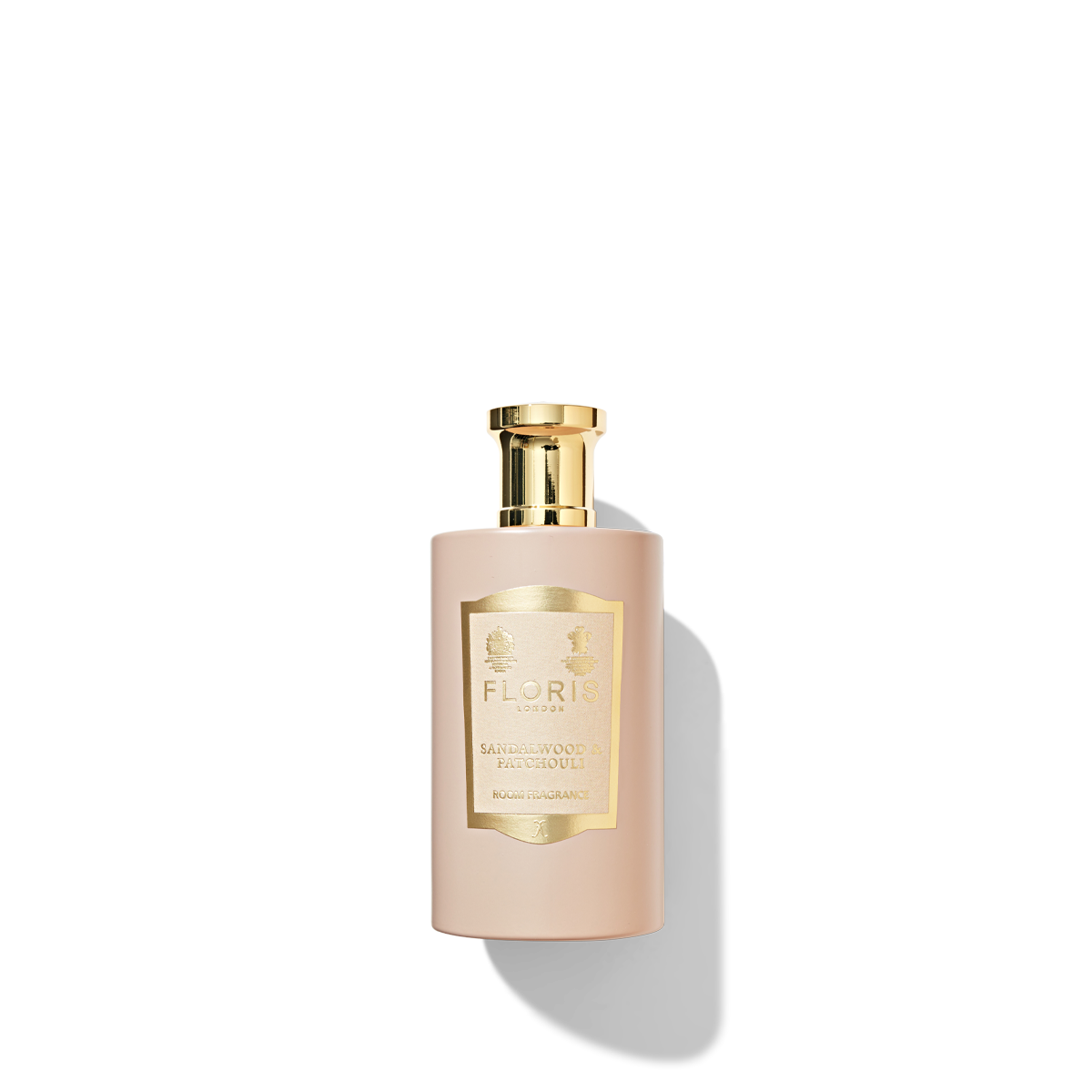 Light pink coloured bottle with a gold cap containing the sandalwood and patchouli room fragrance.