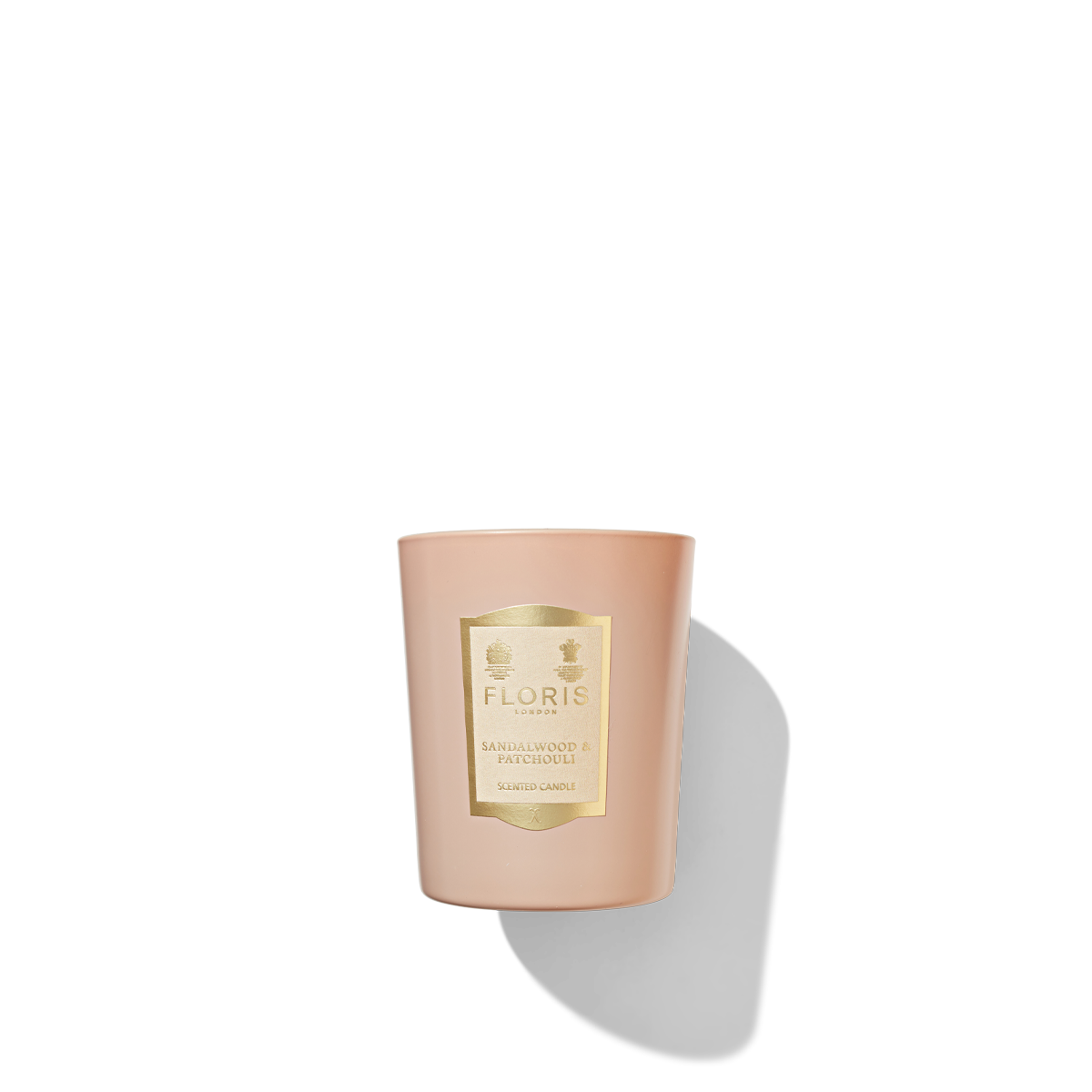 A light pink candle jar with a  light pink and gold label reading 'Floris London sandalwood and patchouli scented candle'.
